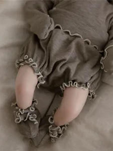 Detailed shot of infant ribbed long sleeve top and high-waisted shorts set in taupe.