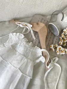 Detail zomer baby romper bandjes gesmockt volant, lichte jacquard babykleding stoffen wit.