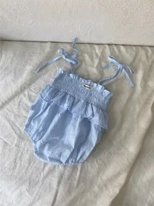 Detail van de lichtblauwe babyromper met schattige volants, bandjes en zachte textuur.