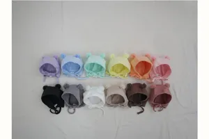 Cute baby bonnet with double pom-poms and ties, soft knit infant hat in multiple colors.