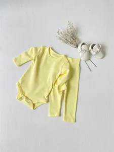 Infant baby yellow long sleeve bodysuit and high waist pants clothing set detail presentation.
