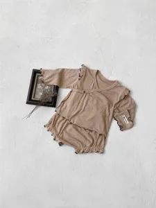 Detailed view of baby fall clothing set, khaki ribbed long-sleeve top and bloomers with frills.