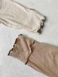 Infant clothing long sleeve cuff detail, soft ribbed fabric with lettuce edge design.