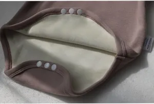 Detailed close-up of baby romper interior, showing thick fleece lining and snap button design.