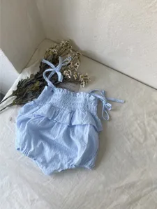 Lichtblauwe baby romper detail, verstelbare strikbandjes, gesmokte top met ruches.