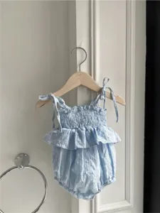 Gedetailleerd overzicht van de zomer baby meisje lichtblauwe bretels gesmokte romper.