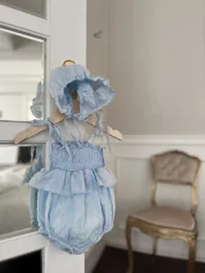 Lichtblauwe zomer baby romper met bandjes jacquard gesmokte gelaagde volants en mutsje.