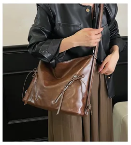 Retro braune slouchy Schultertasche mit Reißverschlüssen und Schleifen für den Alltag.