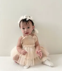 Cute baby girl tulle dress detail shot, smocked strap infant romper with delicate floral headband.