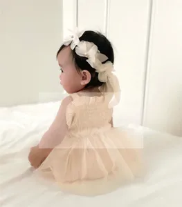 Detailed view of baby girl summer smocked strap mesh romper dress with floral headband.