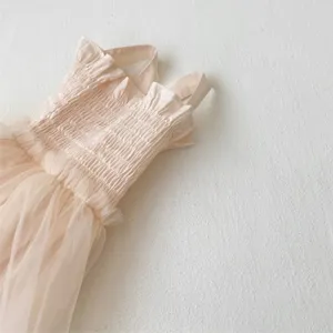 Detail shot of baby girls summer smocked ruffle strap mesh dress romper fabric close-up