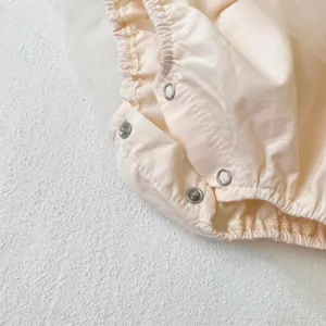 Baby girl mesh romper detail view, sweet summer infant bodysuit with snap buttons and ruffles.