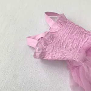 Detail shot of pink baby girl smocked ruffle strap tulle romper dress summer princess bodysuit.