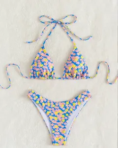 Gedetailleerd overzicht van blauwe bikinitop en -broekje met vrolijke madeliefjesprint.