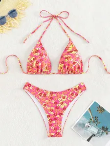 Gedetailleerde close-up van de roze bloemige bikiniset met haltertop en hoge bikinibroek.
