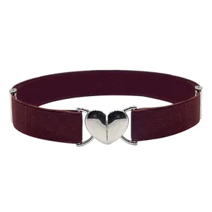 Close up detail of brown elastic waist belt featuring a silver heart metal buckle.