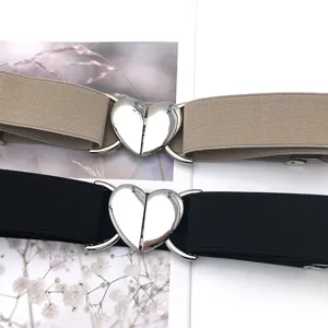 Detailed shot of elastic waist belt with silver heart metal buckle in two classic colors.