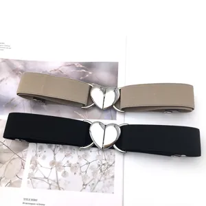 Women decorative elastic waist belt with silver heart buckle for dress coat detail view.