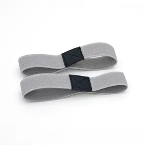 Detail shot of grey elastic high heel shoe straps featuring black cross-stitched leather patch.