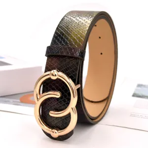 Nahaufnahme eines eleganten Damengürtels in Schlangenhautoptik mit schöner goldener Schalle.