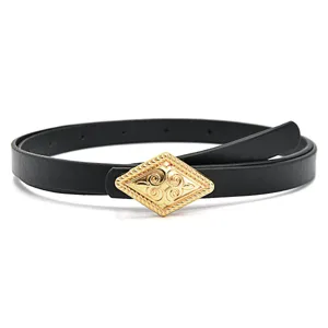 Close-up of women's thin black leather belt with gold ornate diamond metal buckle.