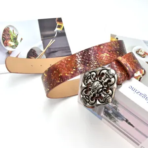 Ceinture en cuir motif serpent rouge style punk avec boucle crâne en métal lourd.