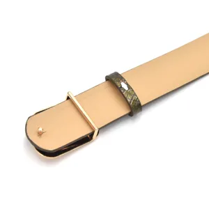 Slim leather belt detail with gold metal closure and textured keeper loop for elegant styling