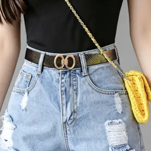 Détail de ceinture avec motif texture serpent et boucle dorée double anneau pour femme.