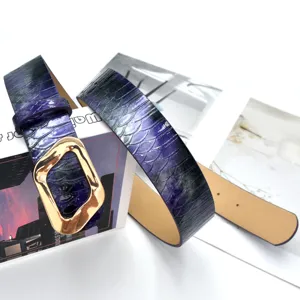 Close-up of a trendy purple snakeskin belt with an irregular gold buckle for denim and dresses.