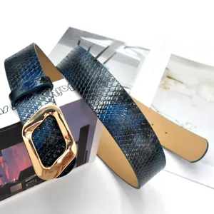 Detailed shot of a blue snakeskin pattern leather belt with a stylish gold irregular metal buckle.