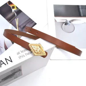 Detailed shot of a stylish thin brown leather belt featuring a vintage gold-tone diamond buckle.