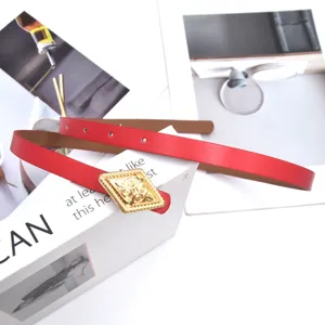 Detailed view of women red thin belt with elegant gold rhombic buckle for dress suits.