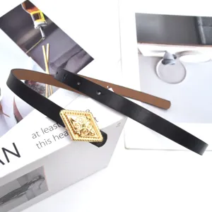 Close-up view of black thin leather dress belt featuring a gold rhombus filigree buckle.