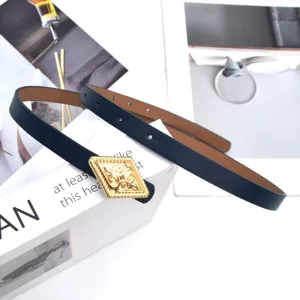 Close up of a chic dark blue skinny leather belt with a vintage gold diamond buckle.