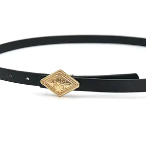Detail shot of a black thin leather belt featuring an ornate vintage gold diamond buckle.