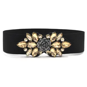 Close-up details of the wide black elastic waist belt with luxury crystal rhinestone flower buckle.