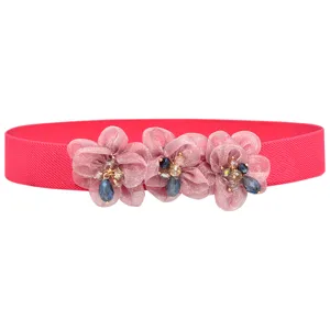 Detail shot of pink elastic belt featuring three fabric flower charms with crystal bead centers.