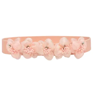 Closeup detail of the pink elastic waist belt decorated with elegant mesh fabric flowers.