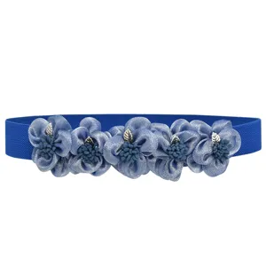 Close up view of blue elastic waist belt featuring fabric flowers with silver leaf accent.