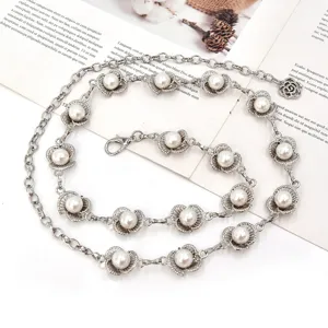 Ceinture chaîne en métal argenté avec perles élégantes et charm floral pour femmes.