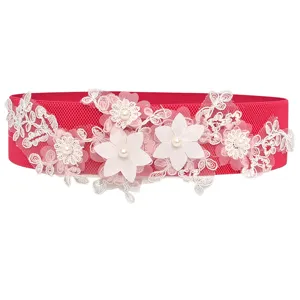 Red elastic waist belt featuring delicate white lace floral embroidery and faux pearl accents.