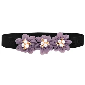 Close-up detail van zwarte elastische tailleband met paarse chiffon bloemen en parel strass.