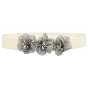 Women's elastic waist belt detail featuring grey mesh fabric flowers with sparkling rhinestones.