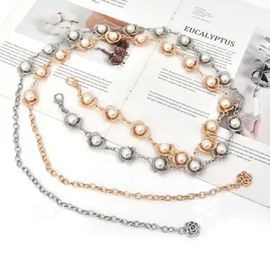 Détail de chaîne de taille fleur perle métal, ceinture argent et or élégante mode.