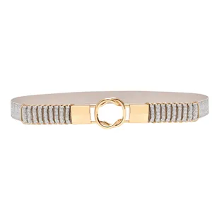 Detailed view of women stretch elastic belt with gold metal round buckle and silver glitter.