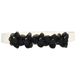 Women's elastic waist belt with black floral decoration, stylish accessory for dresses.