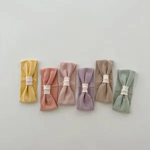 Soft infant headband detail featuring cute bow knots in multiple pastel colors for babies.