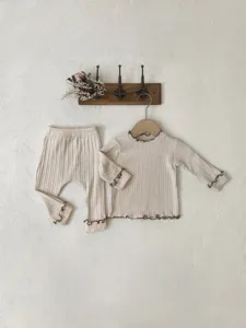 Close-up view of ribbed baby long-sleeve top and big PP pants set with cute lettuce edges.