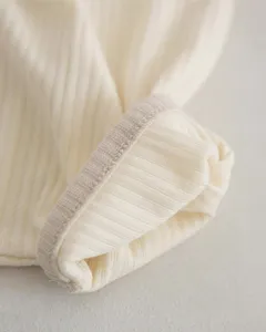 Infant baby ribbed cotton fabric detail close-up showing texture and contrast edge craftsmanship.