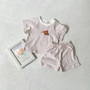 Detailed view of baby summer striped short sleeve t-shirt and shorts clothing set with cute fish.